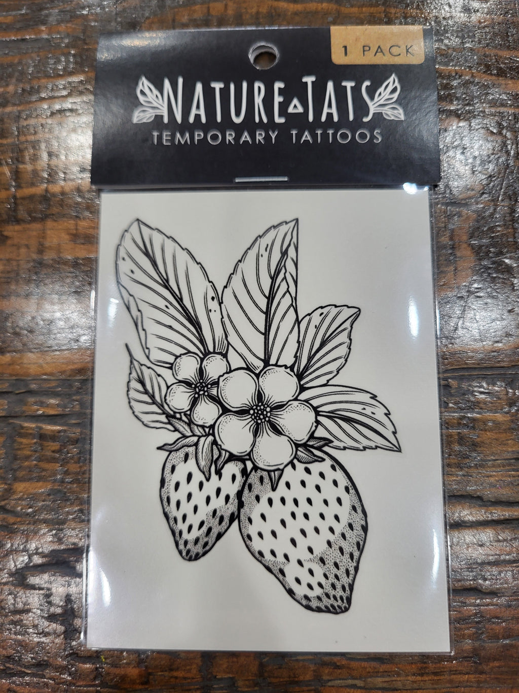 Temporary NatureTats tattoo sheet with black strawberry flower outline on white backing
