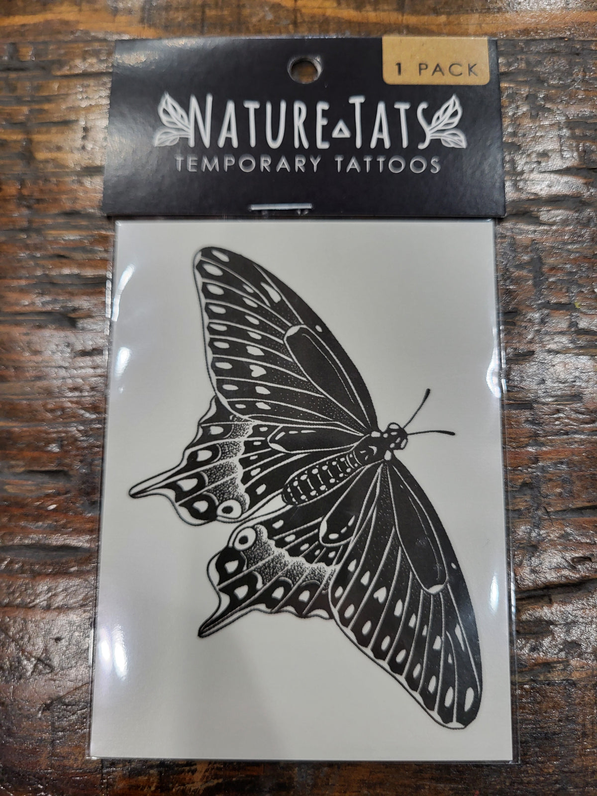 Black swallowtail butterfly temporary tattoo design on card, black ink and white pattern
