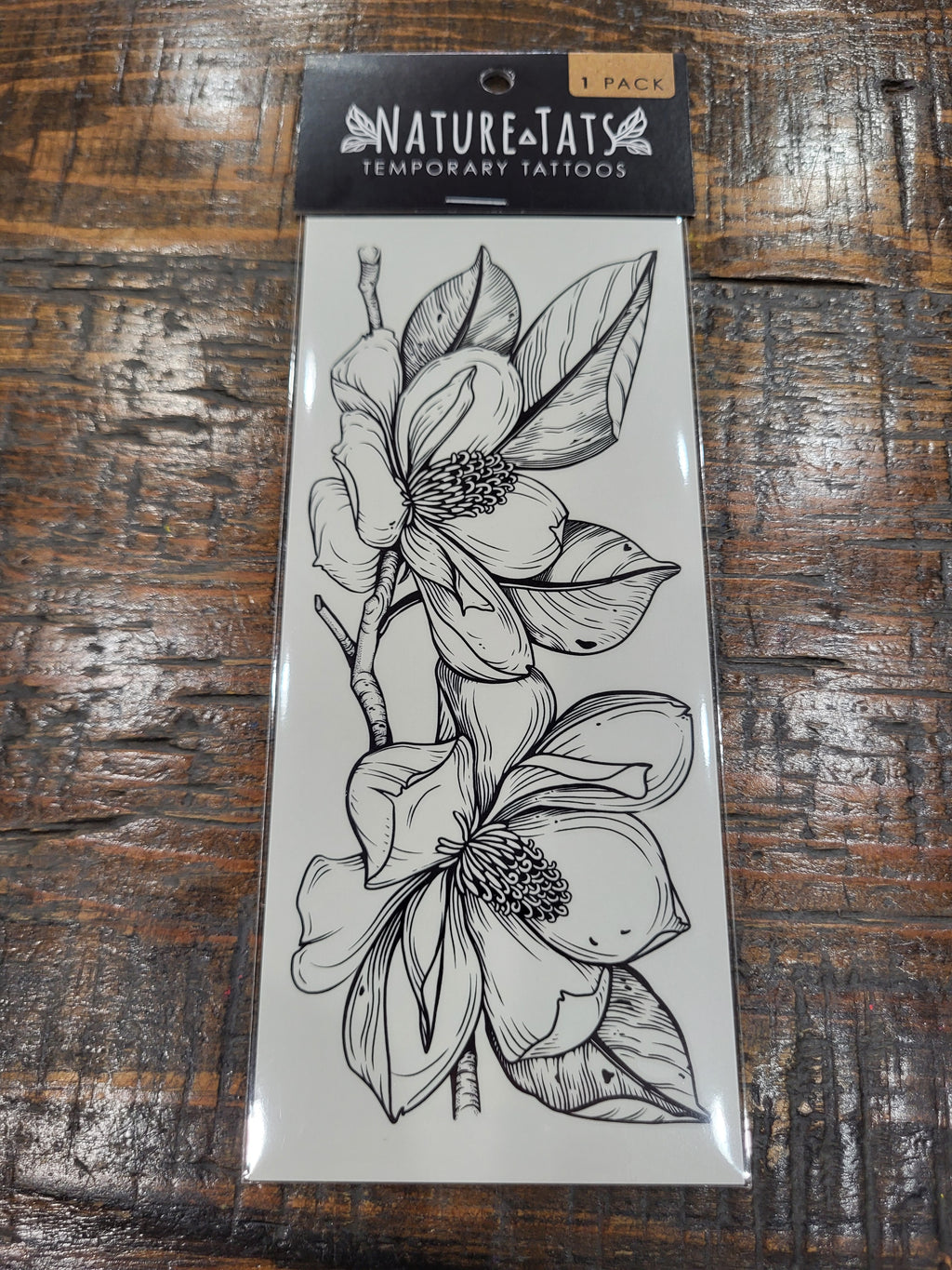 Magnolia flower temporary tattoo pack with black floral line drawing on front