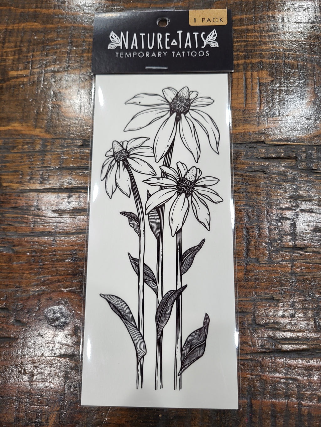 Temporary tattoo pack showing coneflower line-art blooms and leaves on front card