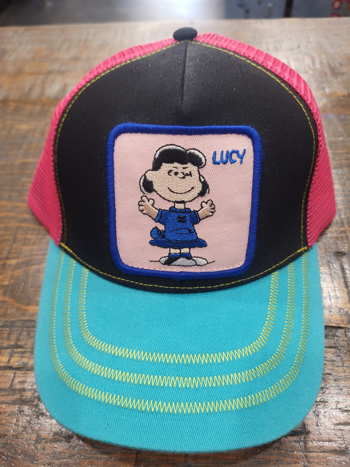 Cotton mesh trucker hat with black front and Lucy patch, pink and teal brim