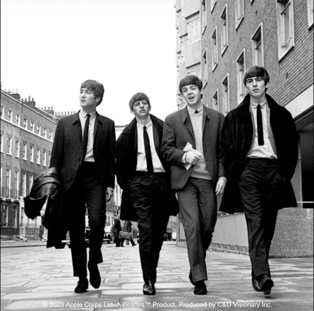 The Beatles band sticker featuring four men in dark suits walking