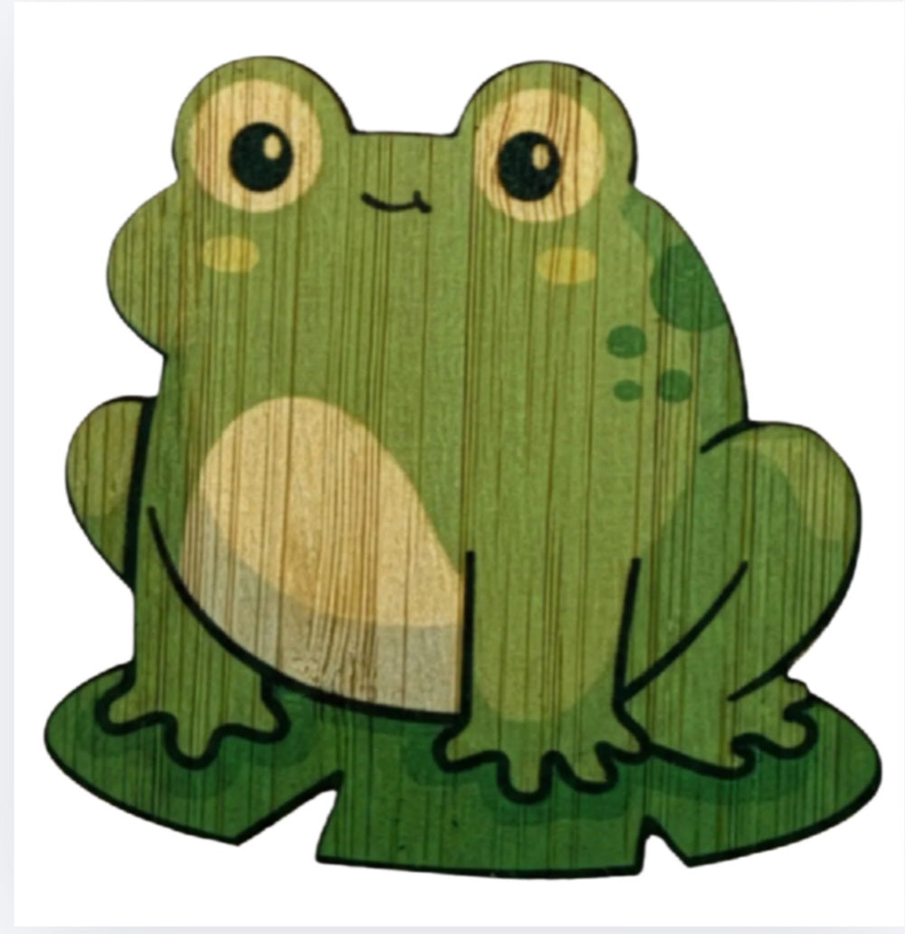 Green frog bamboo sticker, smiling face with large round eyes and textured wood grain.