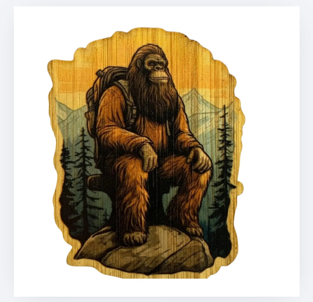 Bamboo Bigfoot sticker of a crouching hairy sasquatch in a pine forest scene