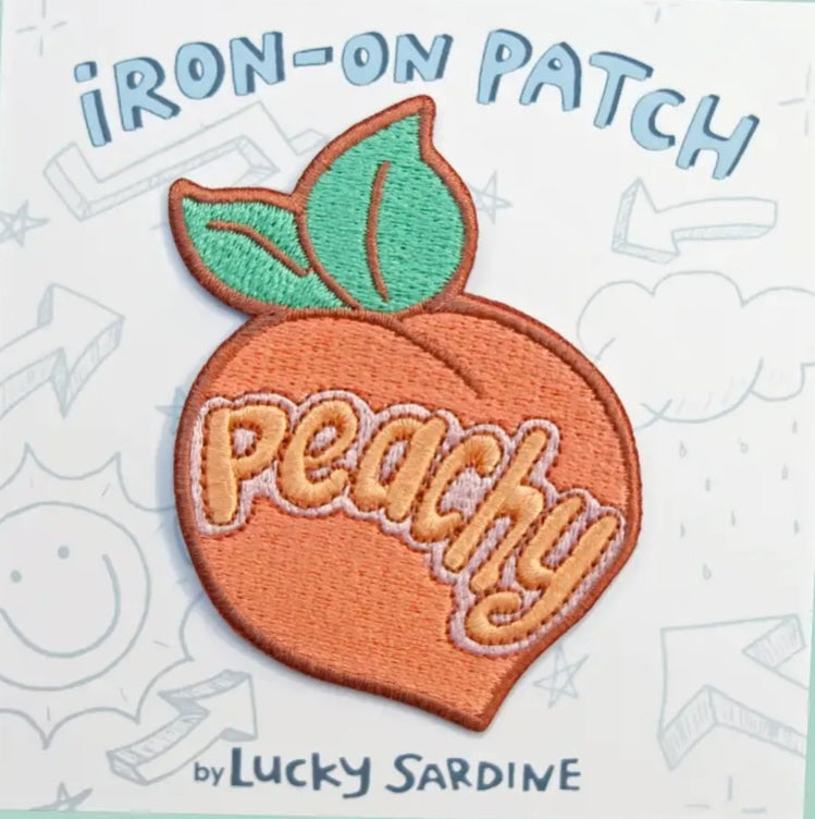 Peachy orange iron-on patch with green leaf and peachy text
