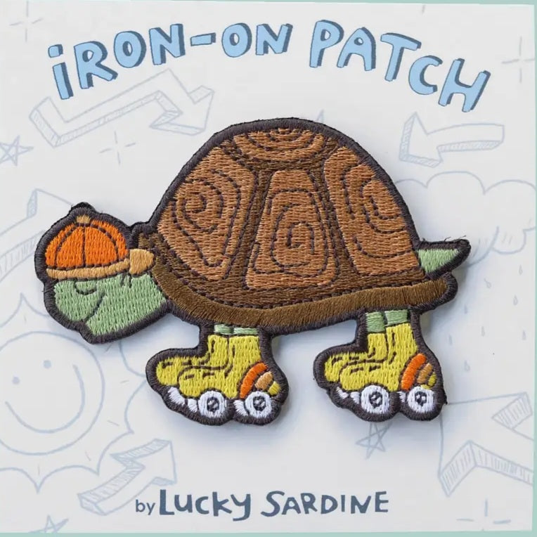 Iron-on patch featuring a brown turtle with orange roller skates and green shell detail
