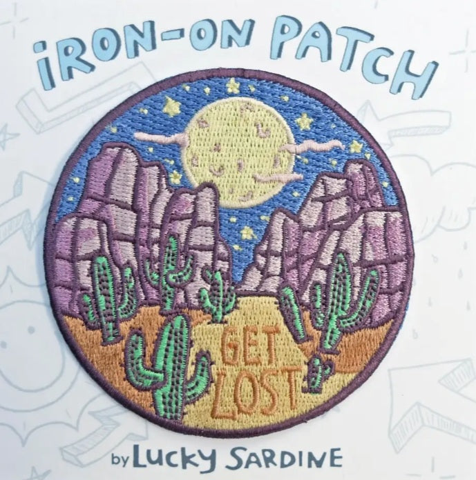 Round iron-on patch with moon over desert, cacti, and 'GET LOST' text