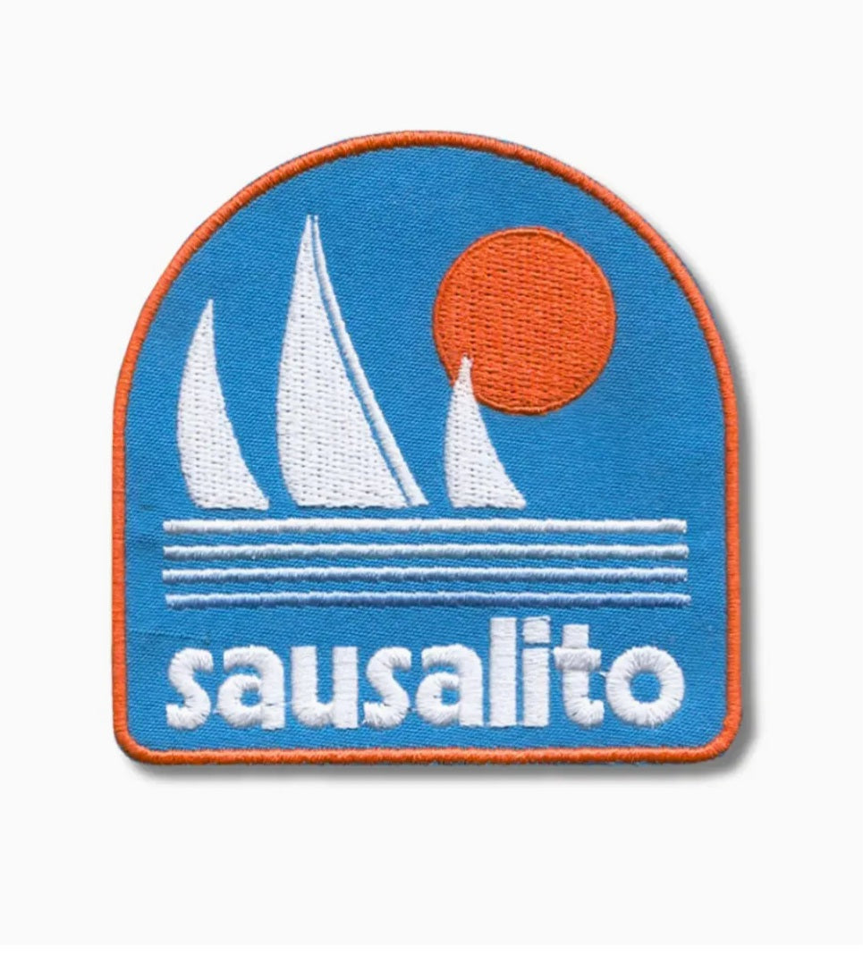 Iron-on patch with blue sea, white sails, orange sun, and word Sausalito.