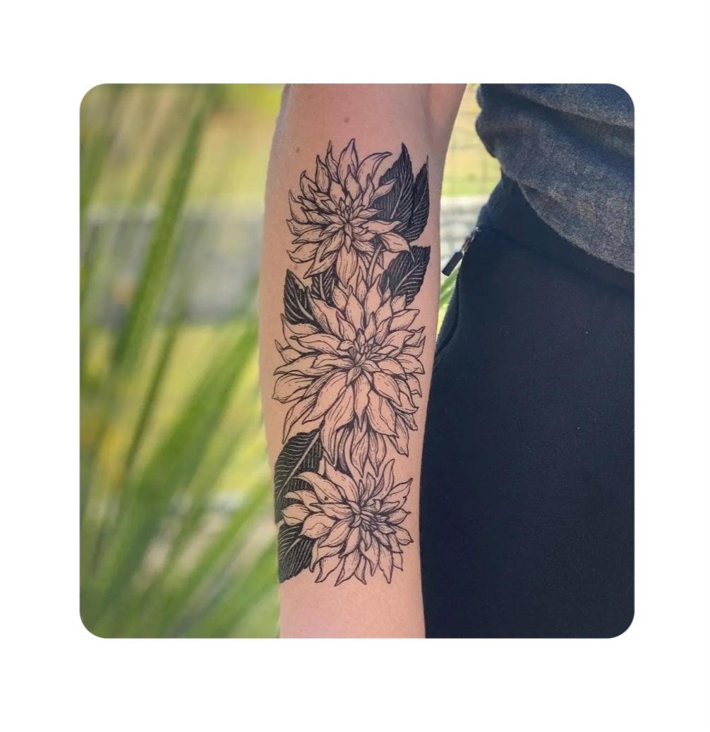 Dahlia flower temporary tattoo on forearm with dark floral line art