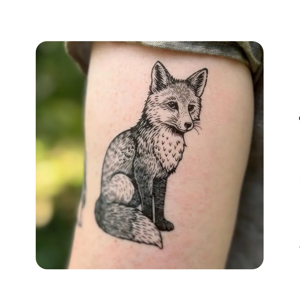 Black-and-white sitting fox temporary tattoo on skin