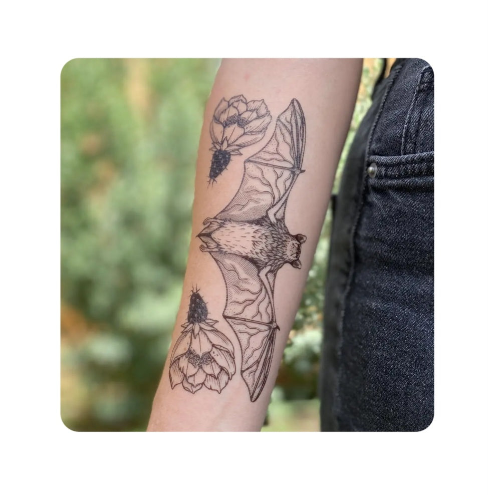 Free-tailed bat temporary tattoo on arm, black-and-gray floral line art