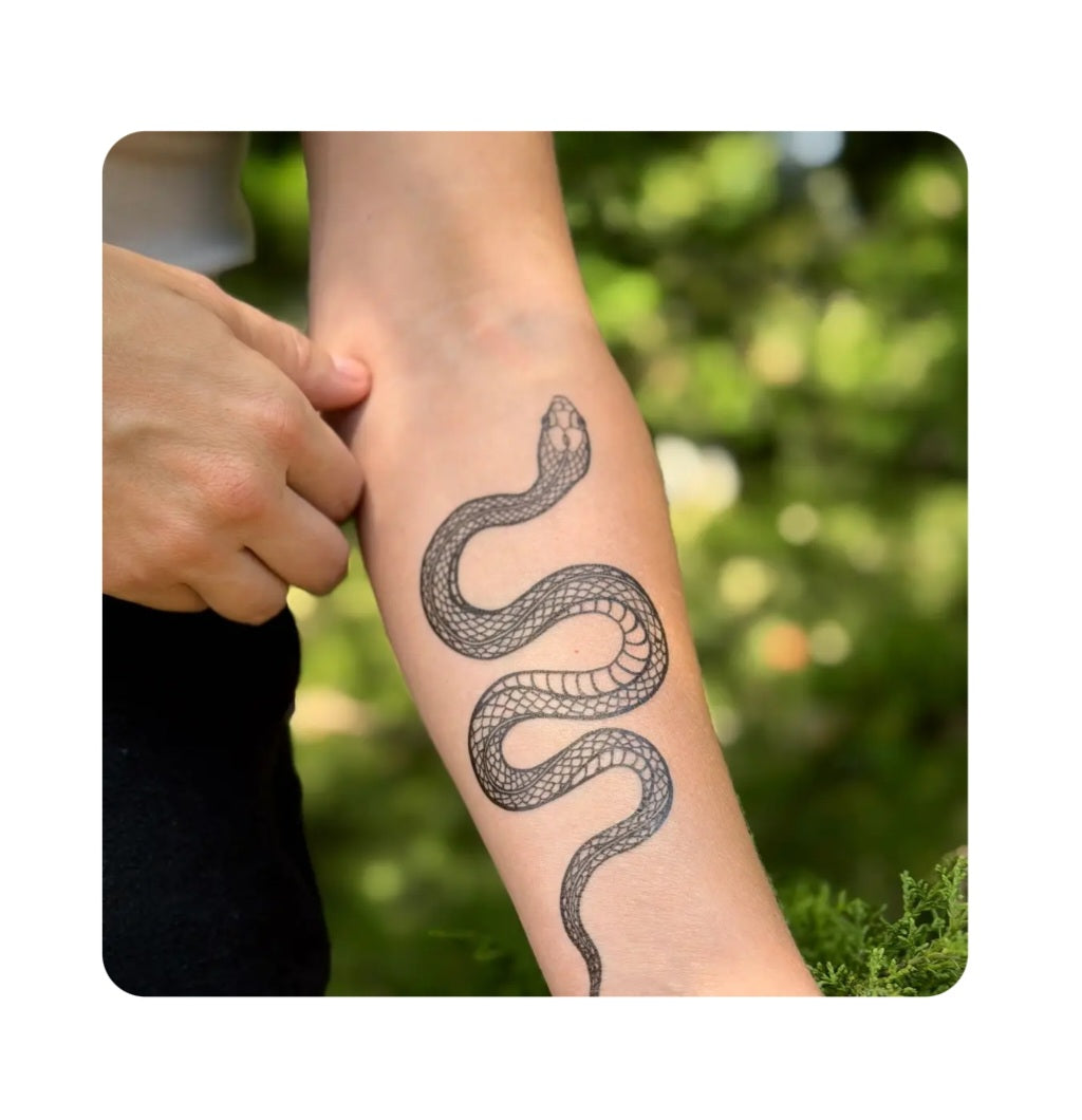 Snake temporary tattoo on forearm, dark linework garden snake design