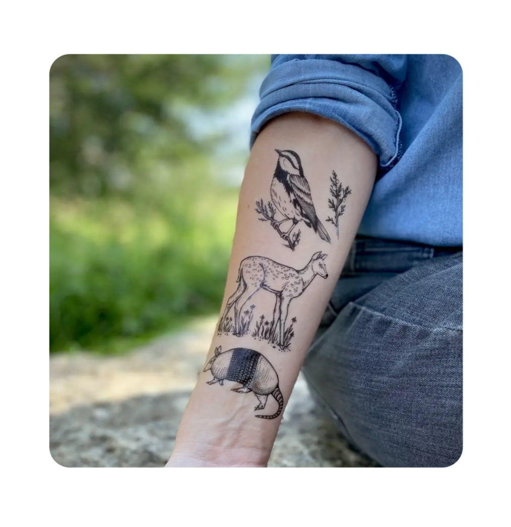 Animal temporary tattoo with bird, deer, and plants on forearm