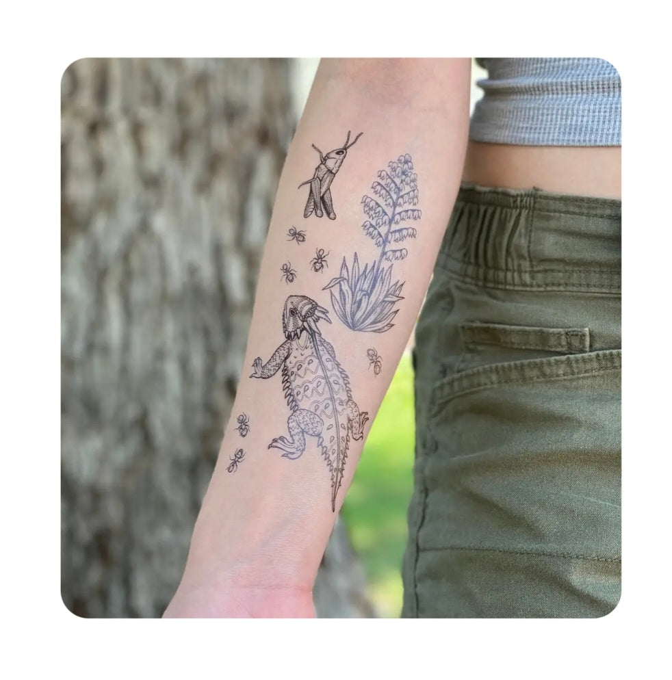 Temporary tattoo on forearm with horned lizard, yucca plants, and small insects