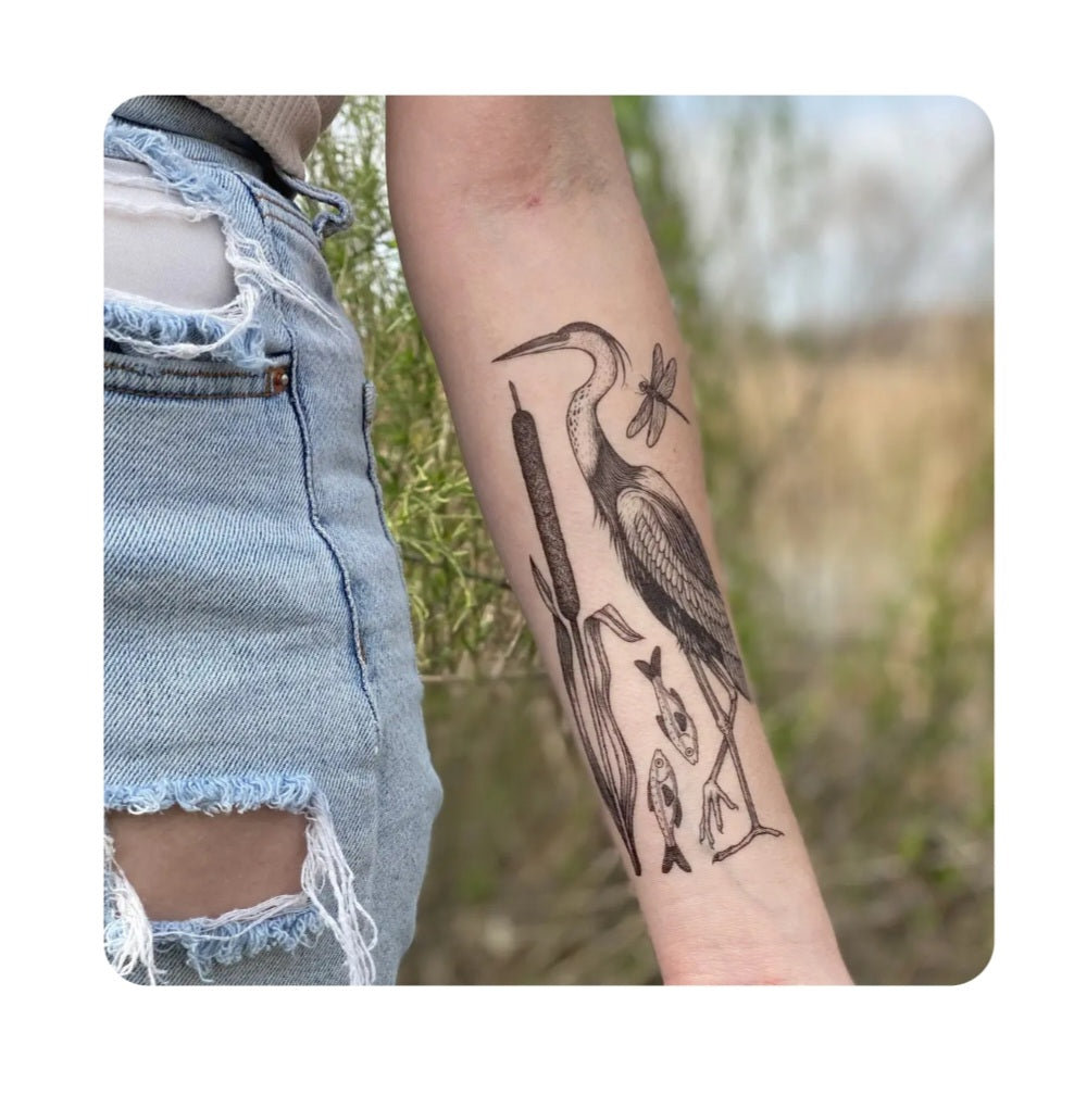 Temporary tattoo on forearm with lake animals: bird, fish, and leaf outlines