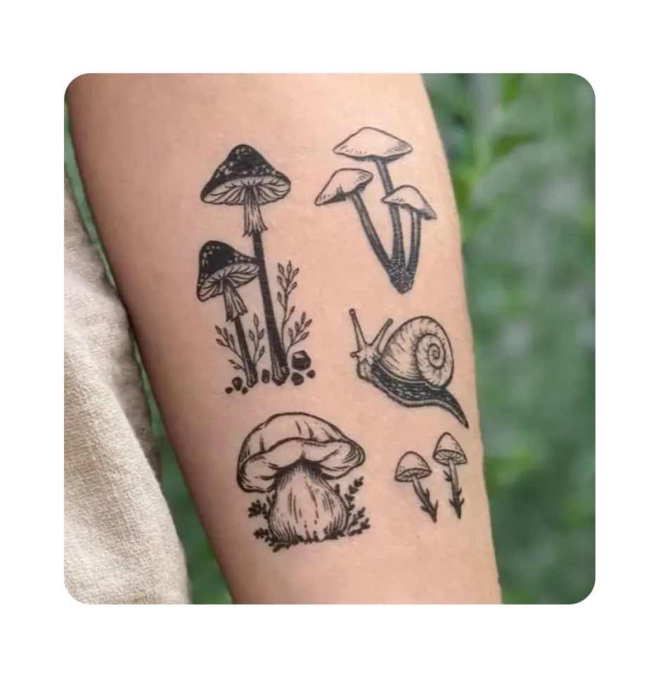 Mushroom temporary tattoos on skin: black-and-gray mushrooms, snail, and vines