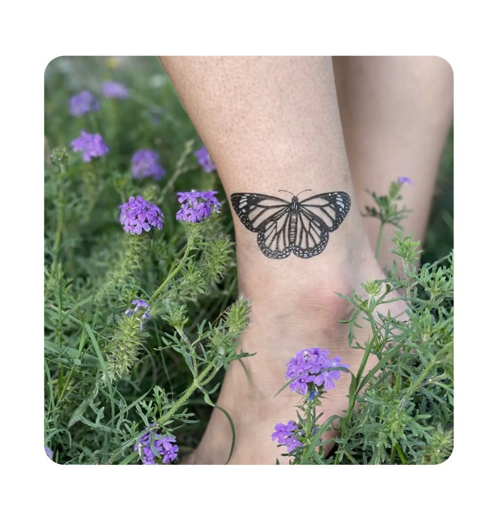Monarch butterfly temporary tattoo on forearm, black ink with dotted wings