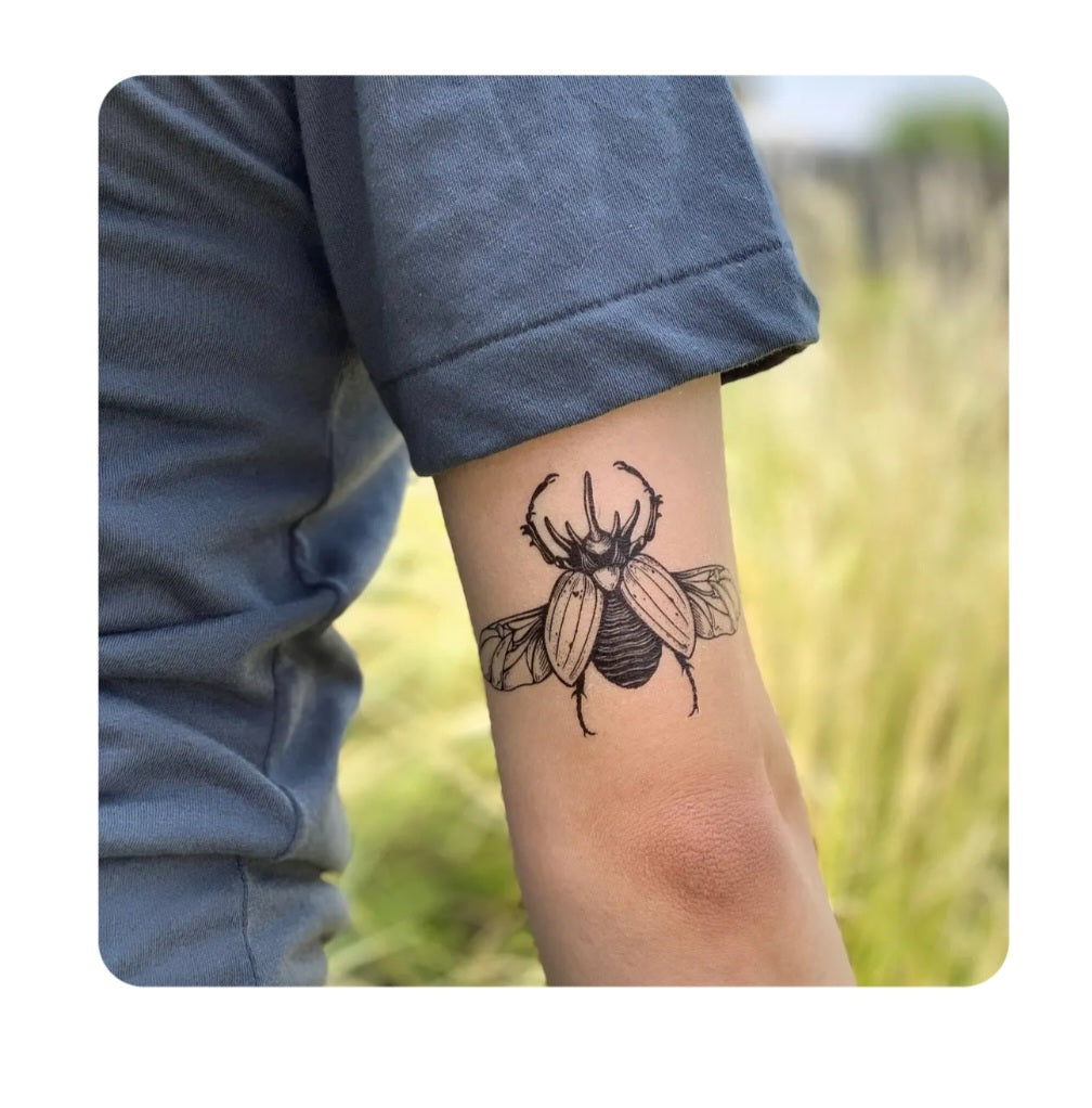 Rhinoceros beetle temporary tattoo on forearm, black ink insect design