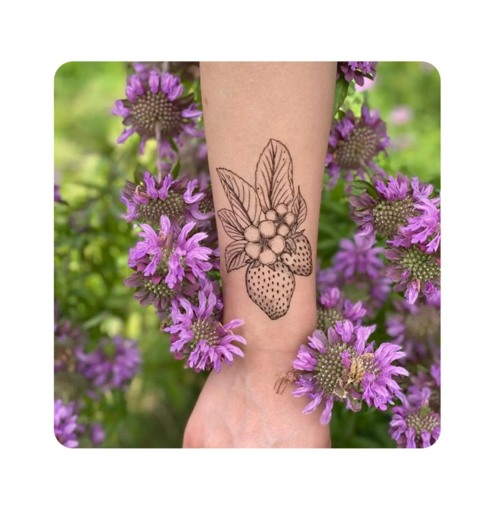 Temporary strawberry floral tattoo on forearm with line-art flower and berries