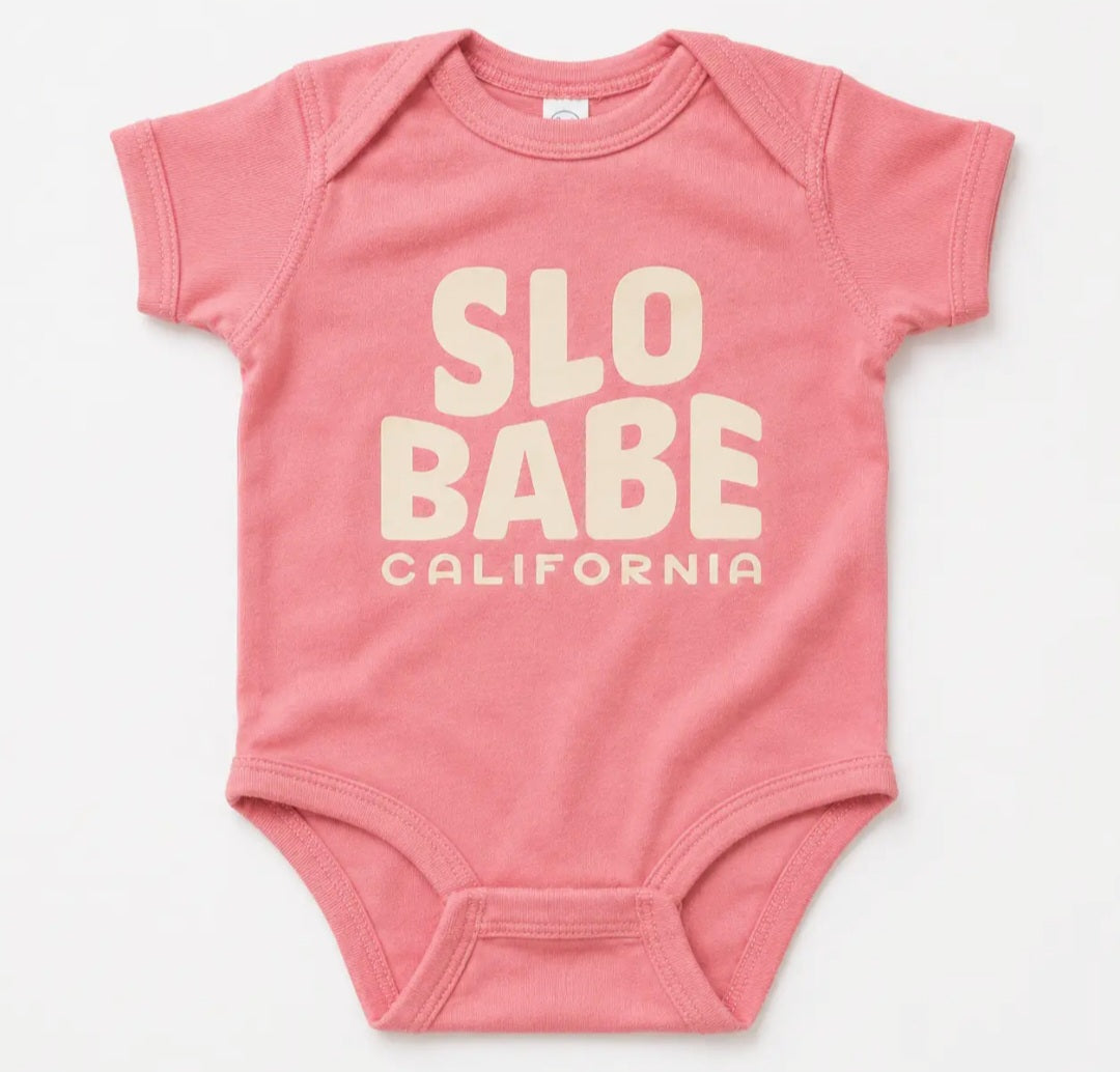 Pink short-sleeve baby onesie with “SLO BABE CALIFORNIA” graphic on front